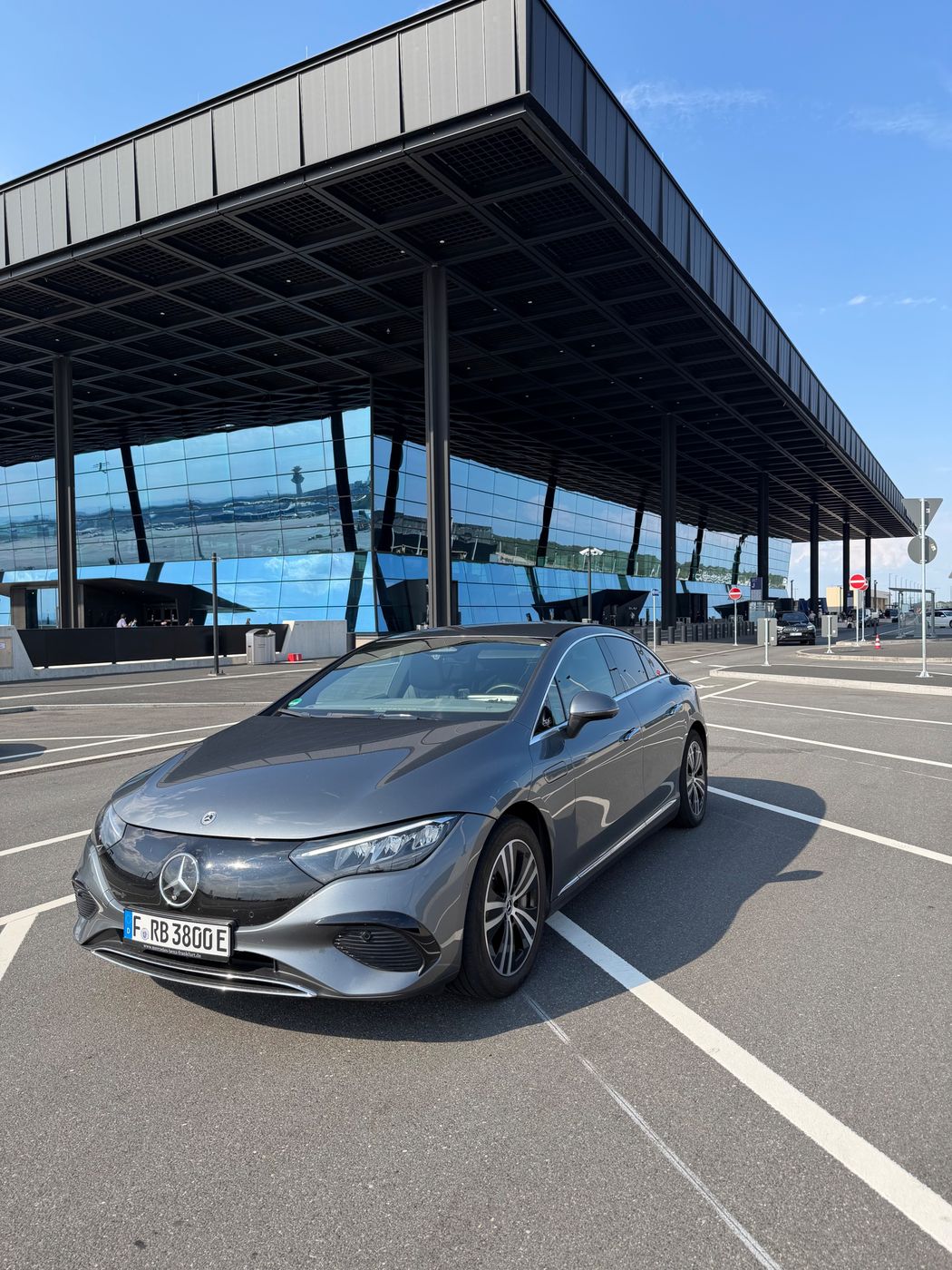 Mercedes EQE von REBA Mobility vor dem Flughafen-Terminal
